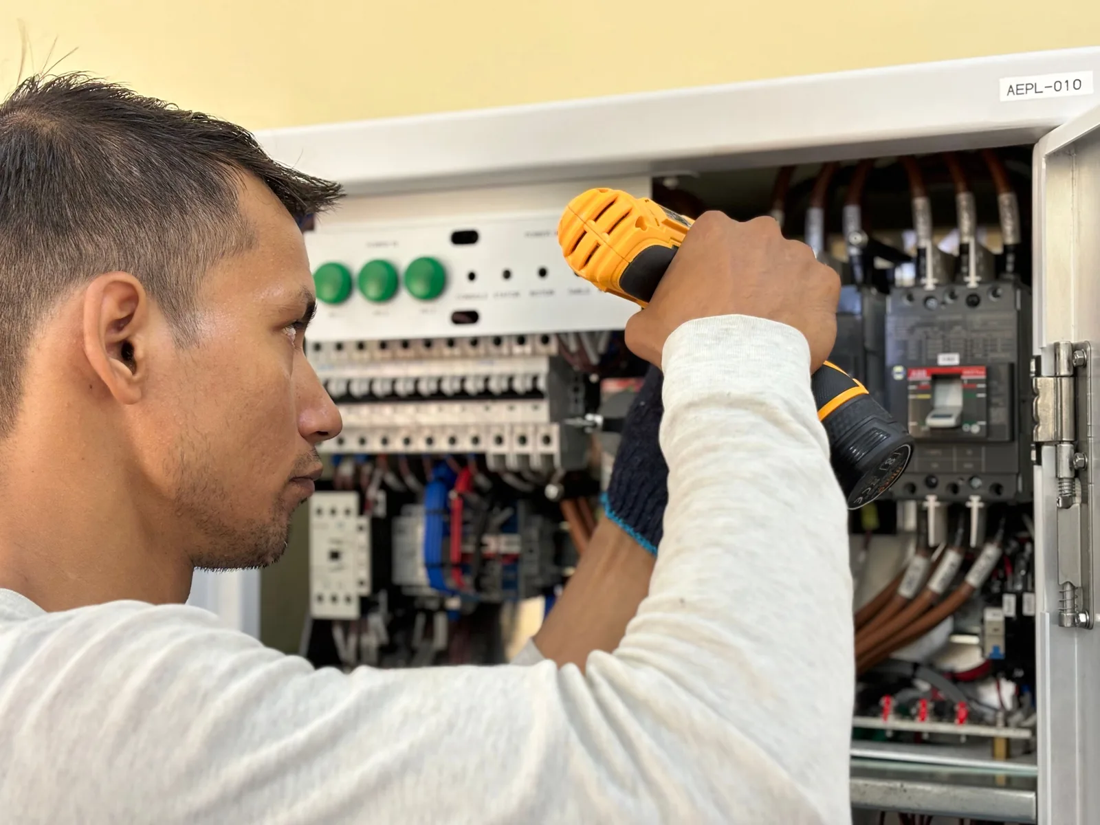 Elektriķis pārbauda atvērtu elektrosadales skapi